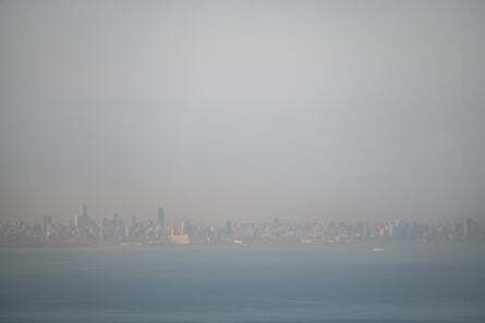 The Beirut skyline, just visible in the far distance amid a haze of smog caused by traffic and generators