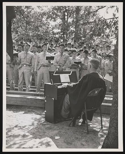 Army chaplain plays a portable organ during Sunday services while members of the all Japanese-American 442-Division combat team sing hymns.