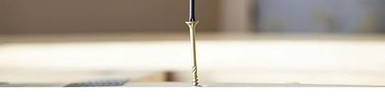 Screwdriver driving a screw into a hole