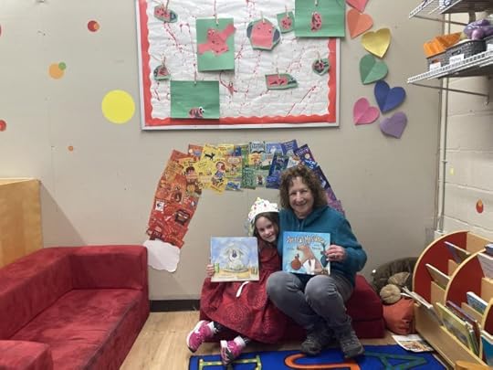Jane and granddaughter leaning together and sitting, smiling and holding 2 books Jane read
