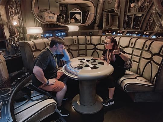 A man and woman inside a replica Millennium Falcon at the Dejarik table