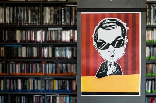 cartoon man in front of a bookshelf