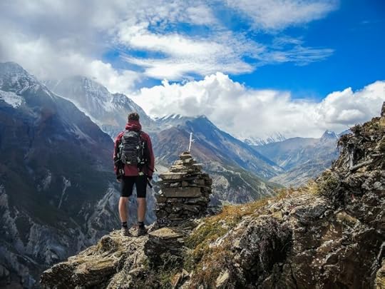 man on a hike in front of a stone pile in the mountains. What do you control?