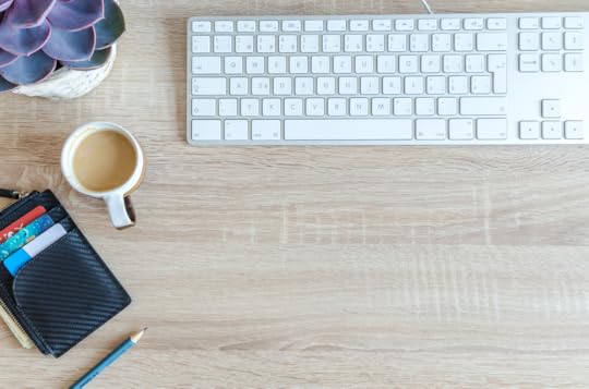 Keyboard and writing supplies on a light wood desk