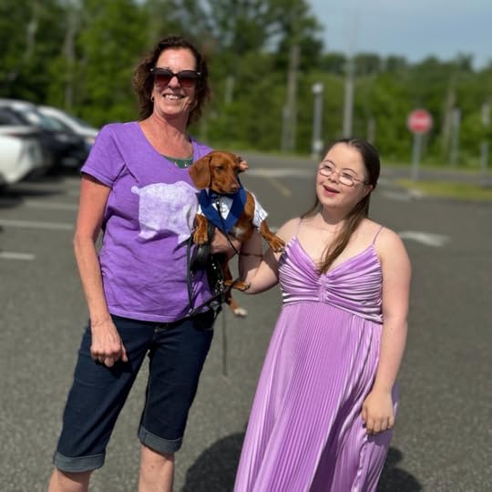 photo in a parking lot of a friend holding a dog and Penny smiling and wearing her prom dress