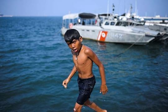 A boy walks alongside the ocean