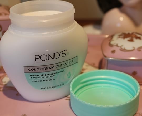 a jar of ponds cold cream. Opened. White with green lid