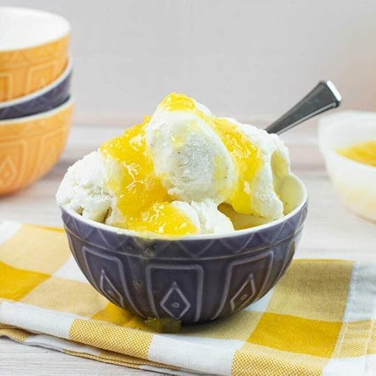 Vanilla ice cream with pineapple sauce in a blue bowl.