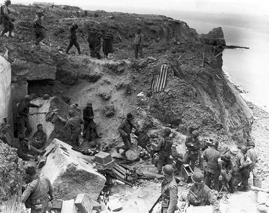 US 2nd Ranger Battalion at Pointe du Hoc after relief on D+2 (June 8, 1944); American flag had been spread out to stop fire of friendly tanks coming from inland. Some German prisoners are being moved after capture (US Army Signal Corps photo: SC190240)