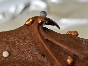 Close up of icing that makes it look like a wave with a ball (really a hundred and thousand) floating on top