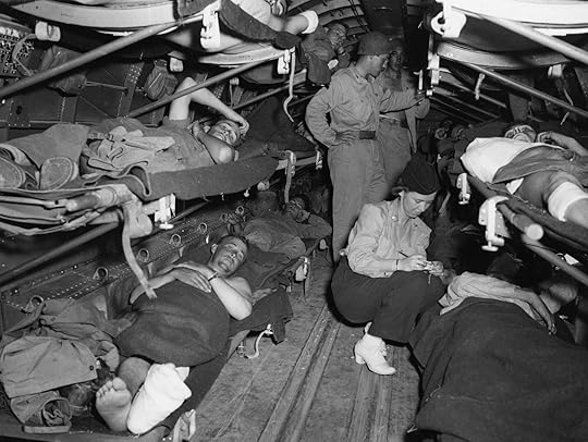 Lt. Katye Swope of the 802nd Medical Air Evacuation Transport Squadron checks patients being evacuated from Agrigento, Sicily to North Africa for further medical treatment, 25 July 1943 (US Air Force photo 25749AC)