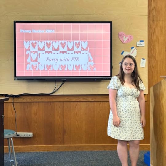 Penny stands next to a TV with her presentation