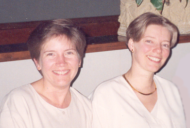 Nicola adn Kelley both wearing white and smiling in a restaurant