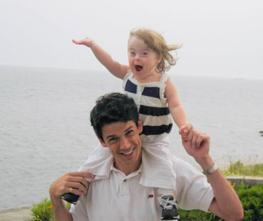 photo from 2008 of Peter holding two-year-old Penny on his shoulders with the ocean in the background]