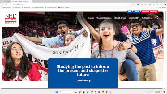 Group of enthusiastic young people, likely students, holding up a banner that says 
