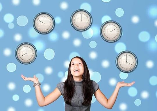 Woman with long brown hair wearing a gray shirt judggline clocks against a bubbly blue background