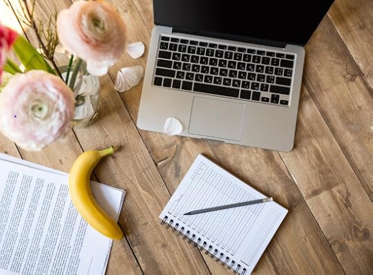 laptop on a desk with notebook, pencil, banana