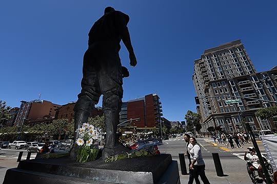 Flowers are left at the foot of a statue of...