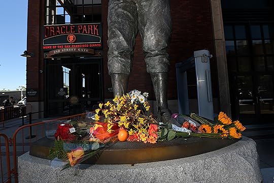 Flowers are left at the foot of a statue of...