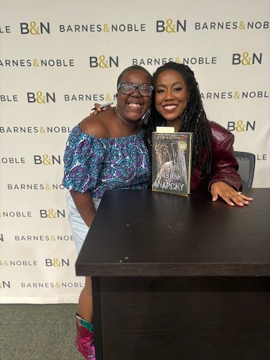 Odochi and Tomi Adeyemi pose together at a book release fan event