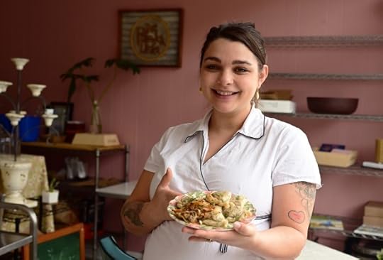A pregnant woman holds a plate of pierogi