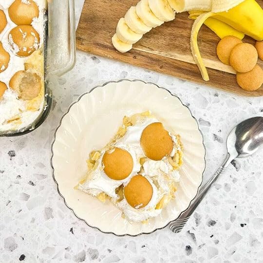 Million Dollar Banana Pudding served on a dessert plate with a banana in background.