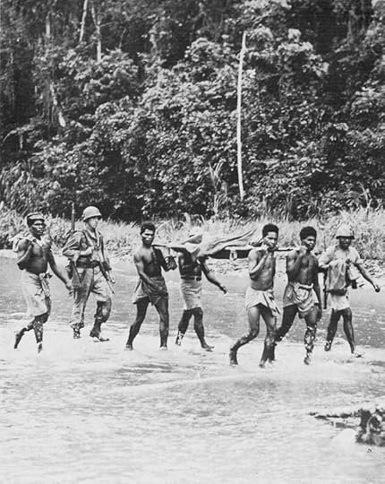 Native litter bearers evacuate an American casualty across the Driniumor River in New Guinea, 1944. (US Center of Military History)