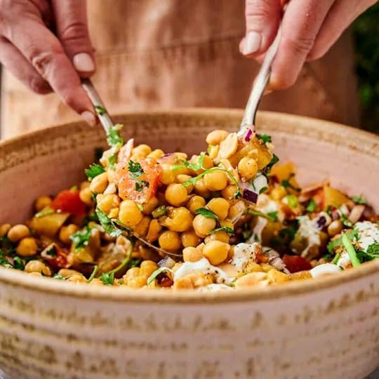 A spoon and fork scooping chana chaat out from its bowl showing off the texture of the chickpeas.