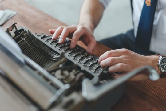 An author typing on a typewriter