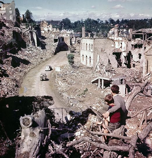Two French boys watch as Allied vehicles pass through the ruins of Saint-Lô, France, July-August 1944 (US National Archives: USA C-2242)