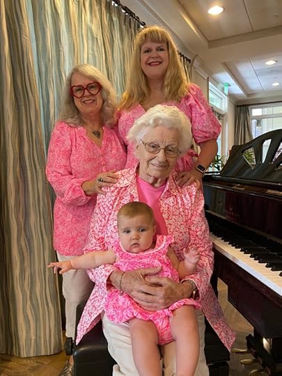3 women + 1 baby, all wearing pink, sitting beside a piano