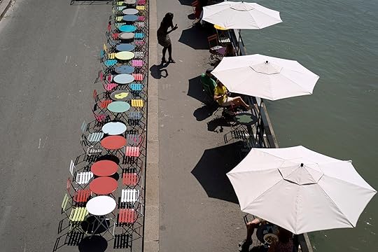 A patron takes a photo while sitting at a cafe along the Seine River, Wednesday, July 17, 2024, in Paris, France, ahead of the 2024 Summer Olympics. (AP Photo/David Goldman)
