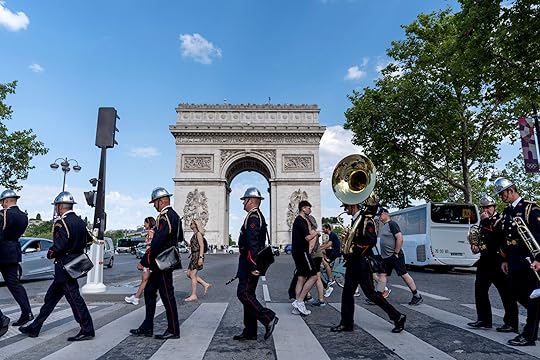 Members of a firefighter brigade band cross the street to perform at a ceremony at the Arc de Triomphe ahead of the 2024 Summer Olympics, Saturday, July 20, 2024, in Paris. (AP Photo/David Goldman)
