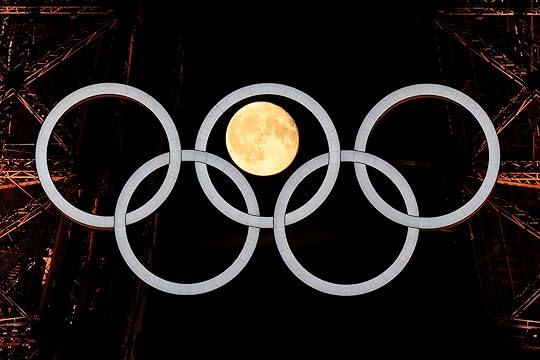 A full moon rises behind the Olympic rings hanging from the Eiffel Tower, Monday, July 22, 2024, in Paris, France. The opening ceremony for the Olympic Games is Friday. (AP Photo/David J. Phillip)