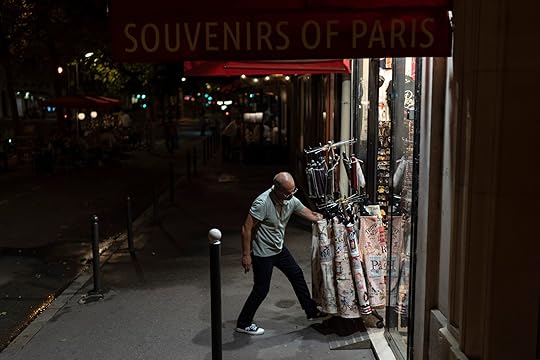 A store owner, who didn't want to give his name, moves a display into his souvenir shop as he closes for the evening near the Eiffel Tower ahead of the 2024 Summer Olympics, Saturday, July 20, 2024, in Paris. He's said he's seen his business decline since a security perimeter went into effect limiting the public's movement near the Seine river. (AP Photo/David Goldman)