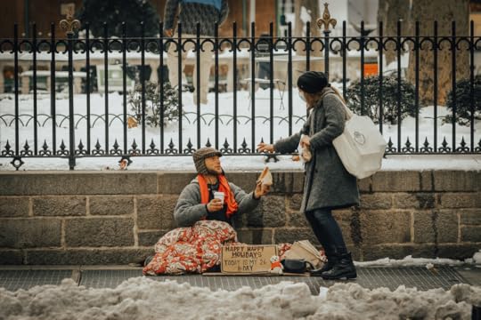 Winter scene with a woman giving food and a hot beverage to a homeless man sitting on a sidewalk