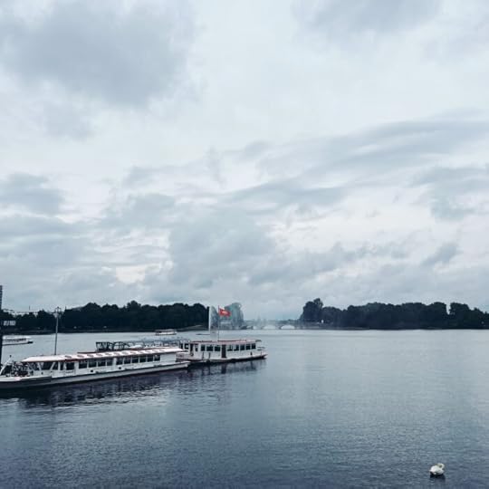 Alsterboote am Anleger Jungfernstieg unter wolkigem Himmel