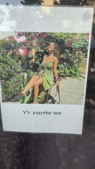 Tamar Goldenbergs wearing a green dress reclining back on a chair with her face to the sunrecliming 