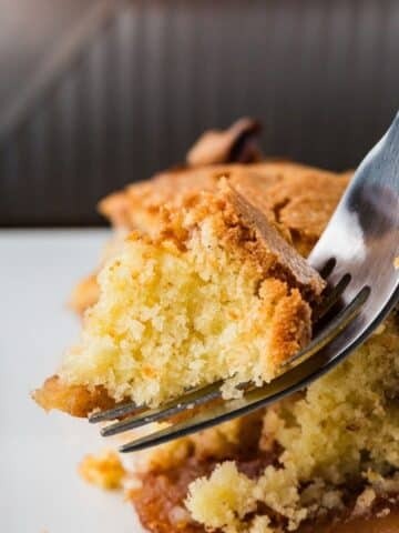 Gala apple cake on a fork ready to for a bite to be taken.