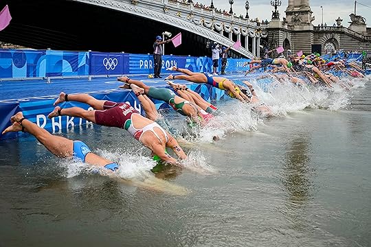 Athletes dive into the water for the start of the...