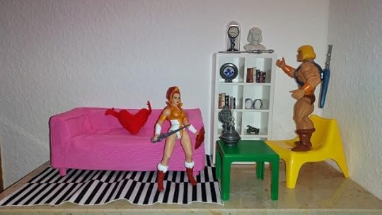 He-Man puts the Sword of Ancients on top of the bookshelf, while Teela looks on.