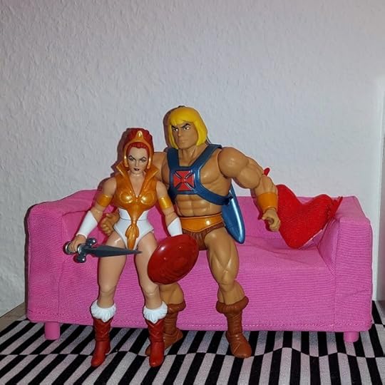 Adam and Teela sit on the sofa.