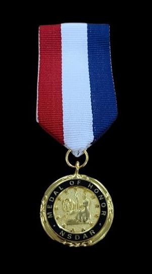 A gold-colored medal with a red, white, and blue striped ribbon attached. The medal has an inscription that reads 