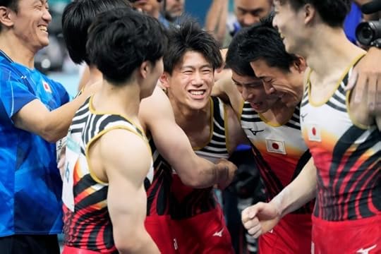 Daiki Hashimoto, of Japan, gets hugged by teammates after performing on the horizontal bar during the men's artistic gymnastics team finals round at Bercy Arena at the 2024 Summer Olympics, Monday, July 29, 2024, in Paris, France. (AP Photo/Charlie Riedel)