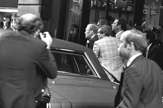 FILE - President Ford ducks behind his limousine and is hustled into the vehicle after a shot was fired as he left the St. Francis Hotel in San Francisco, Sept. 22, 1975. The President was rushed to the airport to return to Washington. (AP Photo, File)
