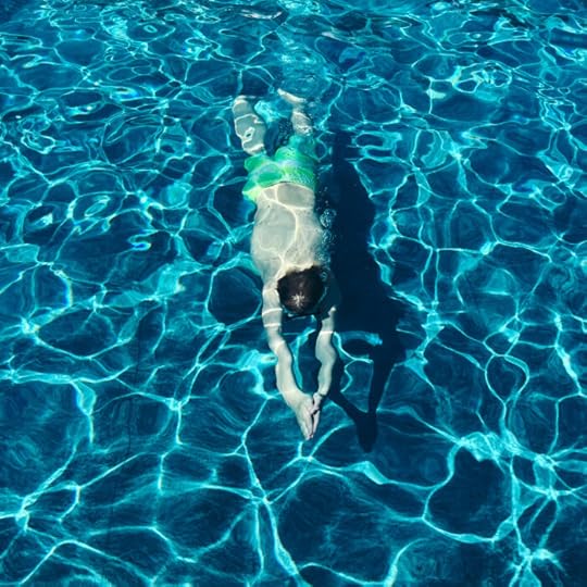 Ein tauchender Sohn im Pool, von oben fotografiert