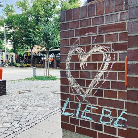 Eine mit Kreide bemalte Ziegelwand, ein großes Herz, unter dem Liebe steht