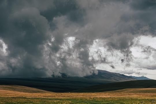 Ominous clouds over mountains and fields