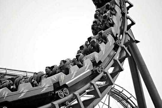 Black and white image of roller coaster cars rolling down the rails
