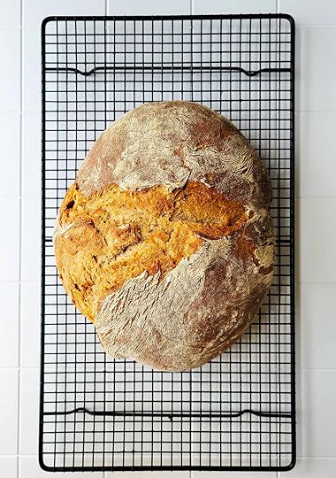 A light rye bread cooling on a rack.